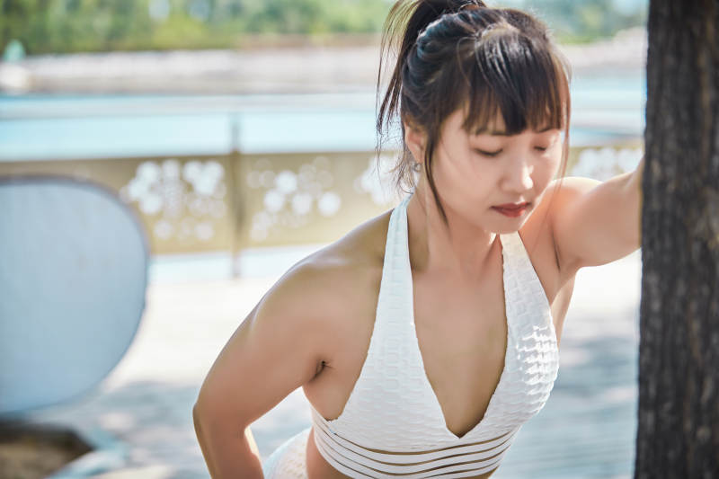 湖畔公园做瑜伽动作的亚洲年轻女性图片