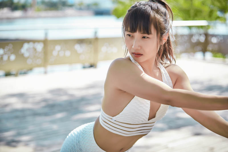 湖畔公园做瑜伽动作的亚洲年轻女性图片