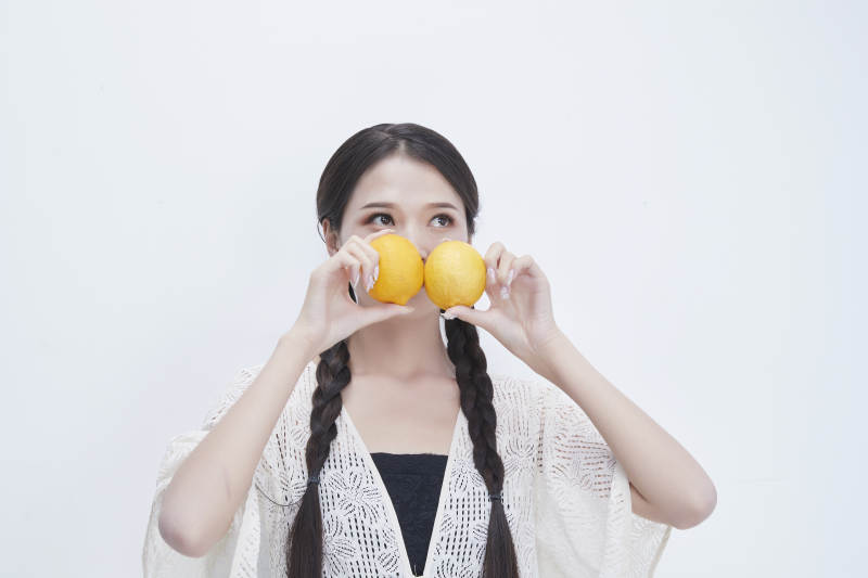 手拿柠檬身穿镂空连衣裙的亚洲可爱少女人像图片