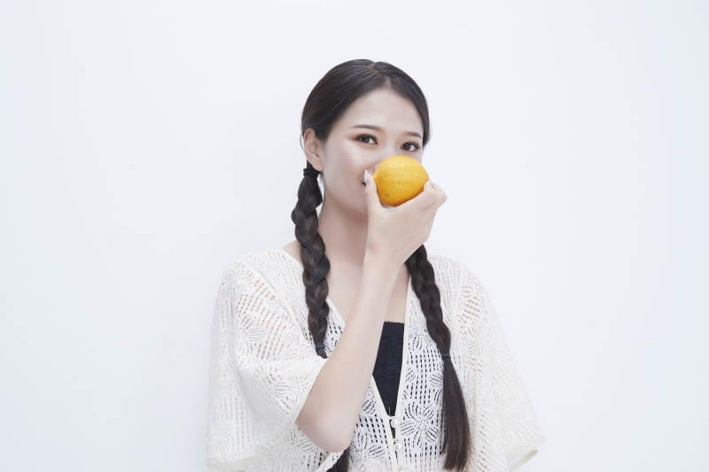 手拿柠檬身穿镂空连衣裙的亚洲可爱少女人像图片