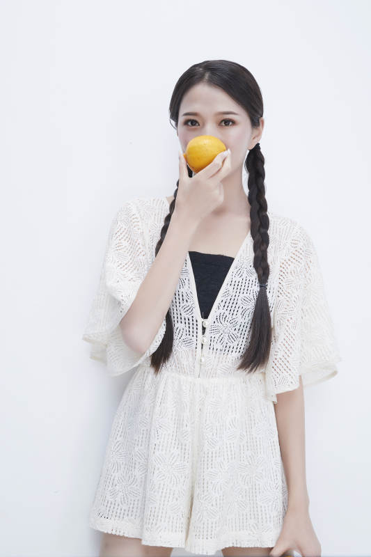 手拿柠檬身穿镂空连衣裙的亚洲可爱少女人像图片