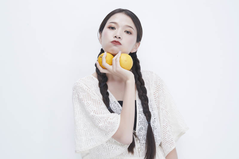 手拿柠檬身穿镂空连衣裙的亚洲可爱少女人像图片