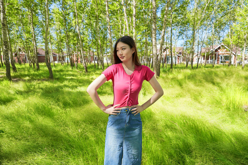 站在绿草如茵的木屋别墅群外的东方美女图片