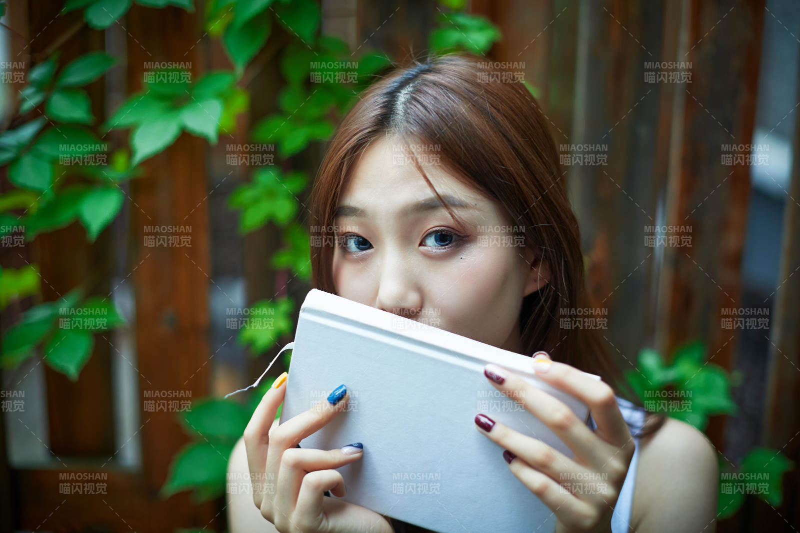 院子里坐在长椅上阅读书籍的亚洲长发少女图片