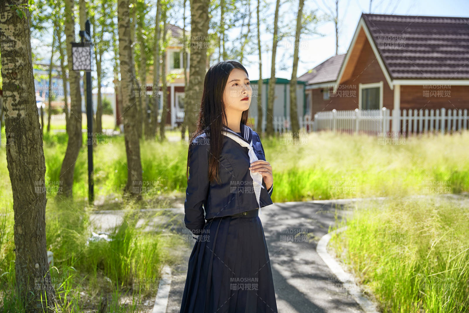 站在绿草如茵的木屋别墅群外的东方美女图片