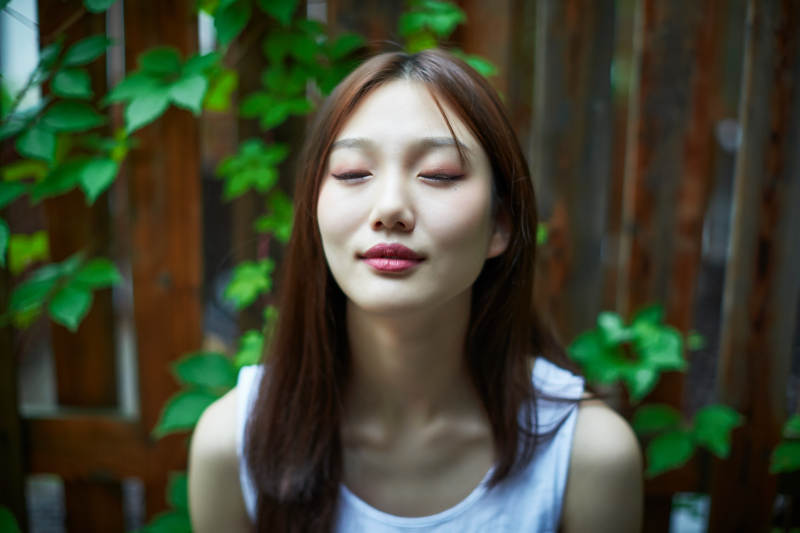 院子里坐在长椅上阅读书籍的亚洲长发少女图片