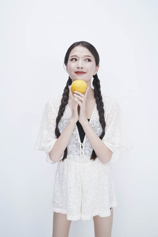 手拿柠檬身穿镂空连衣裙的亚洲可爱少女人像图片