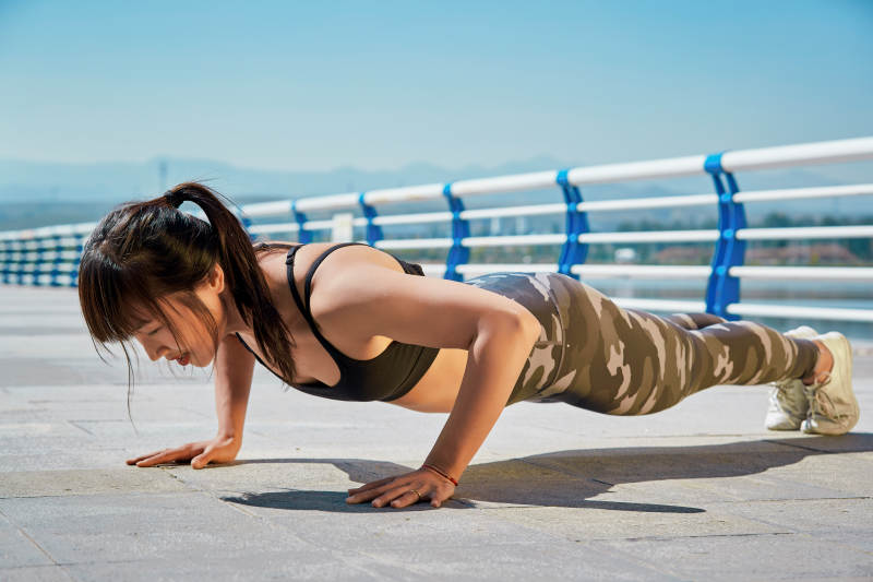 户外河畔公园做拉伸有氧运动的亚洲女性图片