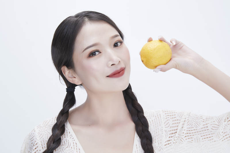 手拿柠檬身穿镂空连衣裙的亚洲可爱少女人像图片