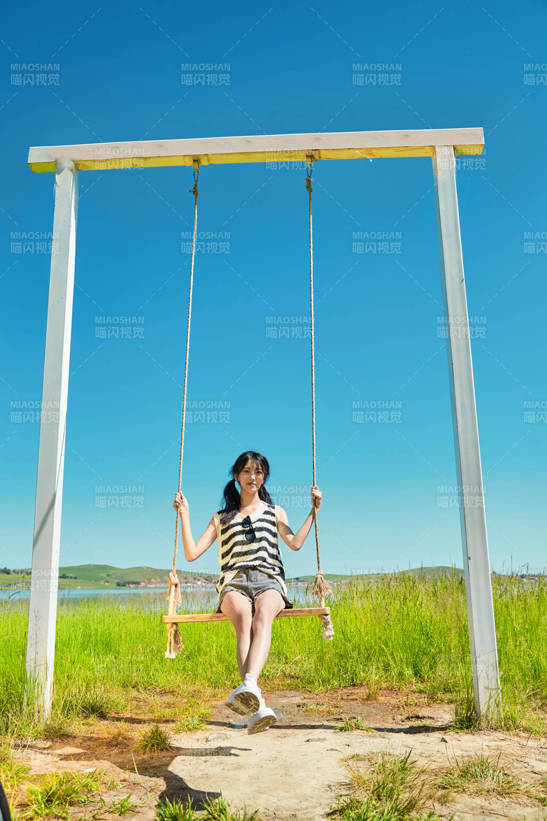 草原湖畔打卡点游玩拍照的亚洲少女图片