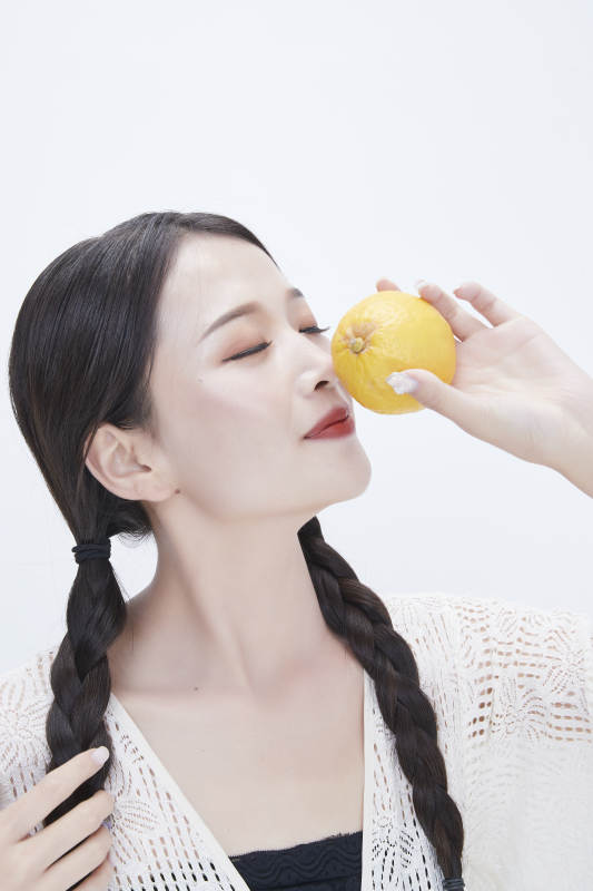 手拿柠檬身穿镂空连衣裙的亚洲可爱少女人像图片