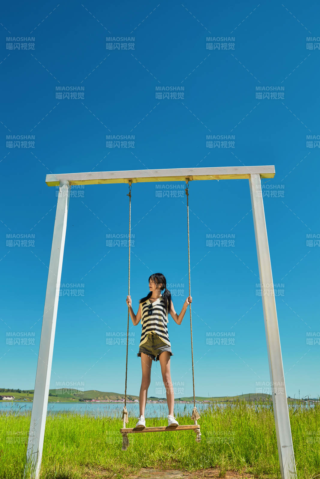 草原湖畔打卡点游玩拍照的亚洲少女图片