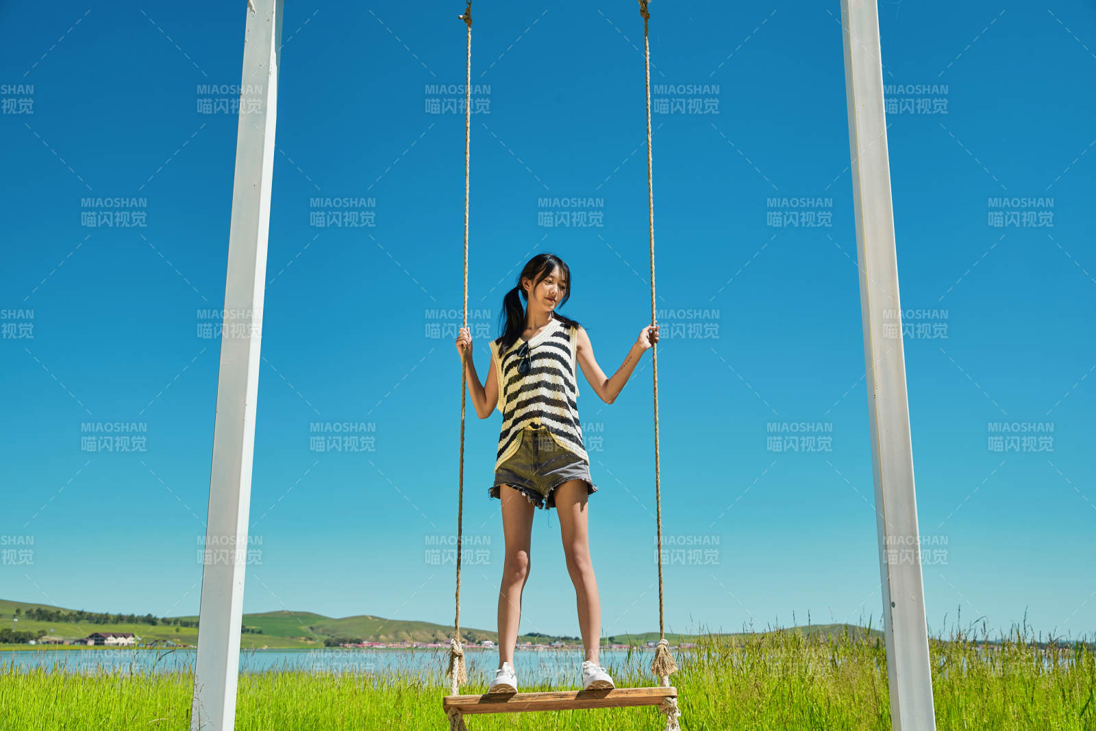 草原湖畔打卡点游玩拍照的亚洲少女图片