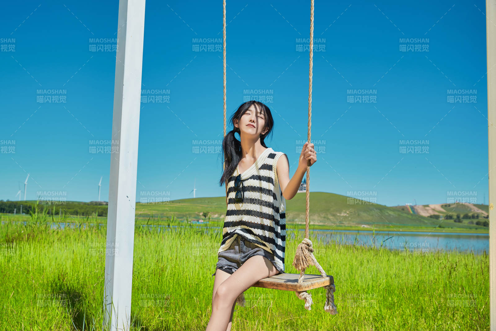 草原湖畔打卡点游玩拍照的亚洲少女图片