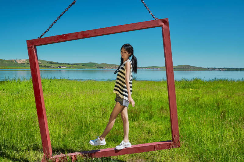 草原湖畔打卡点游玩拍照的亚洲少女图片