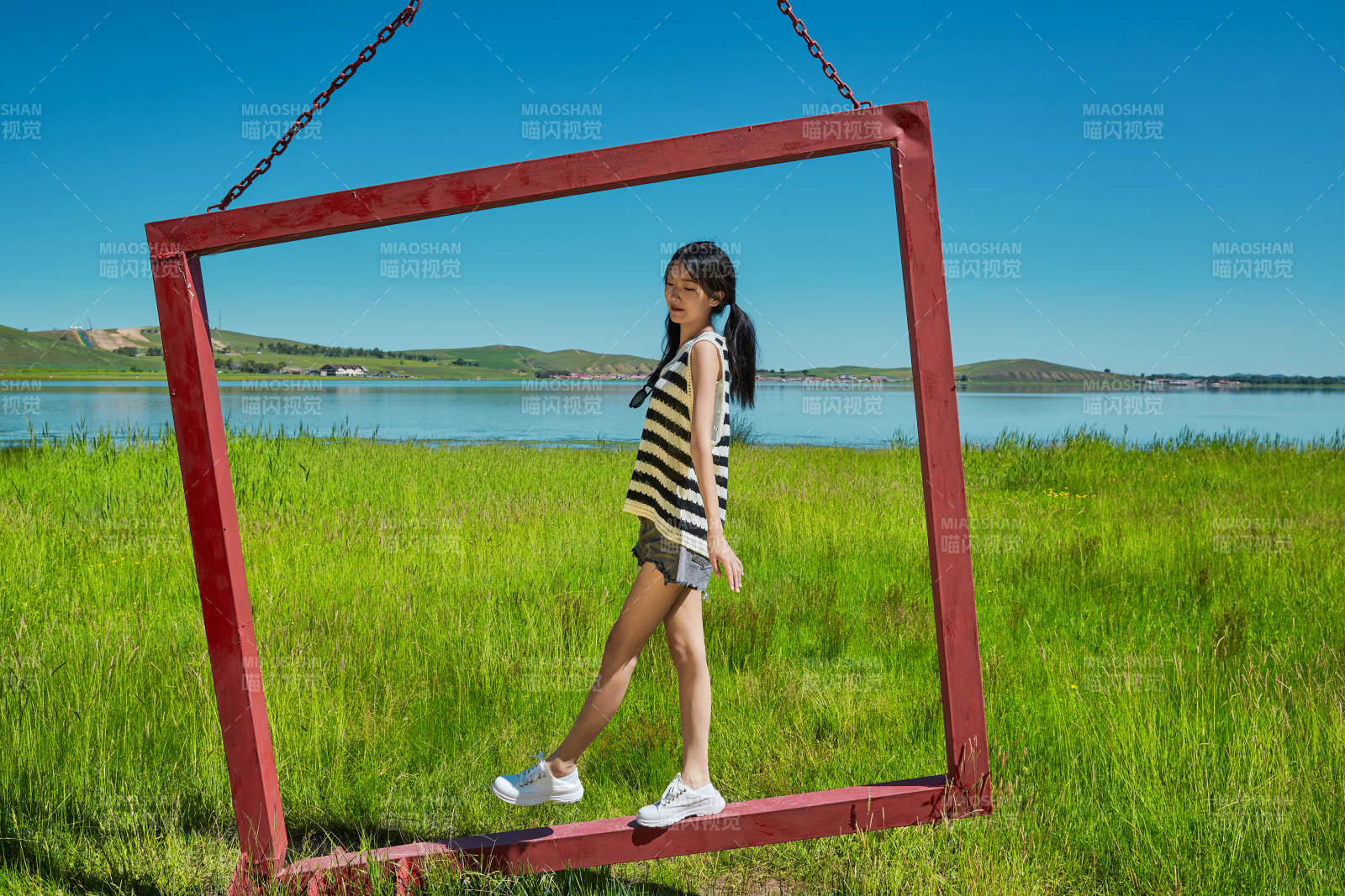 草原湖畔打卡点游玩拍照的亚洲少女图片