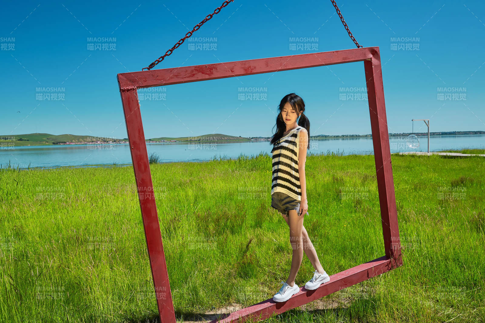 草原湖畔打卡点游玩拍照的亚洲少女图片