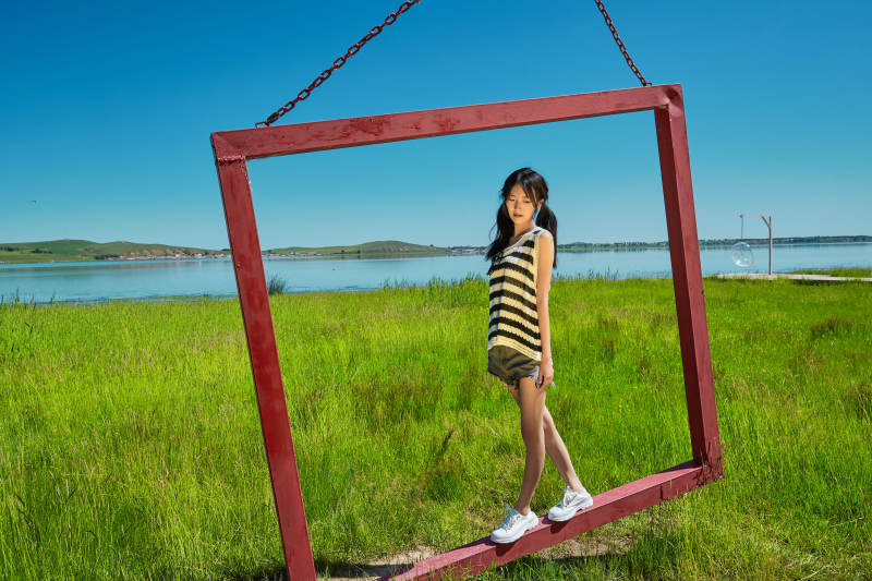 草原湖畔打卡点游玩拍照的亚洲少女图片