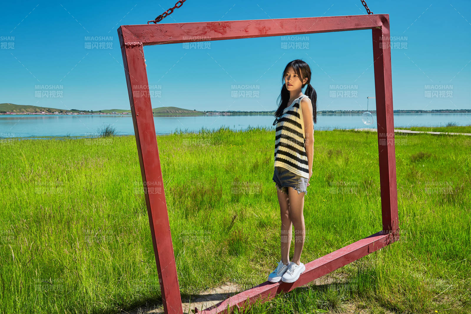 草原湖畔打卡点游玩拍照的亚洲少女图片