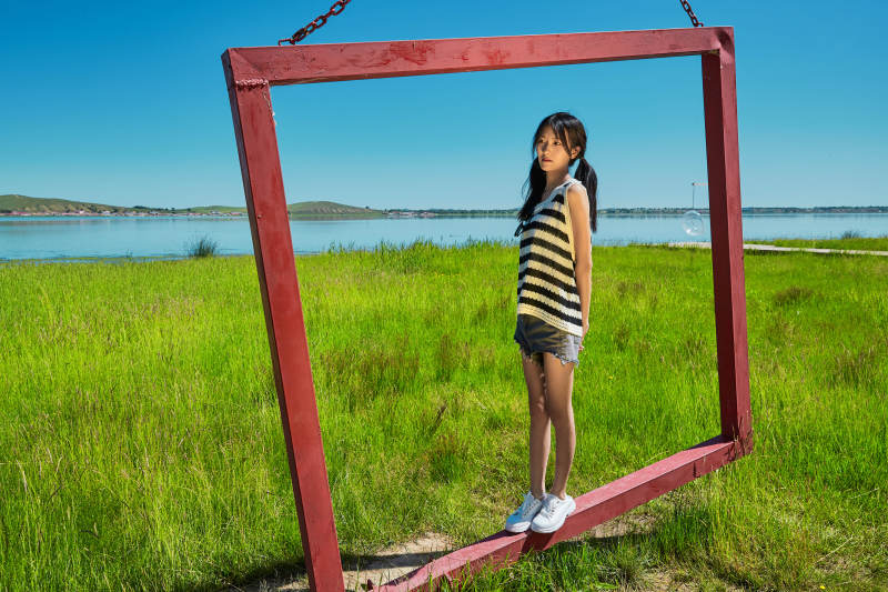 草原湖畔打卡点游玩拍照的亚洲少女图片