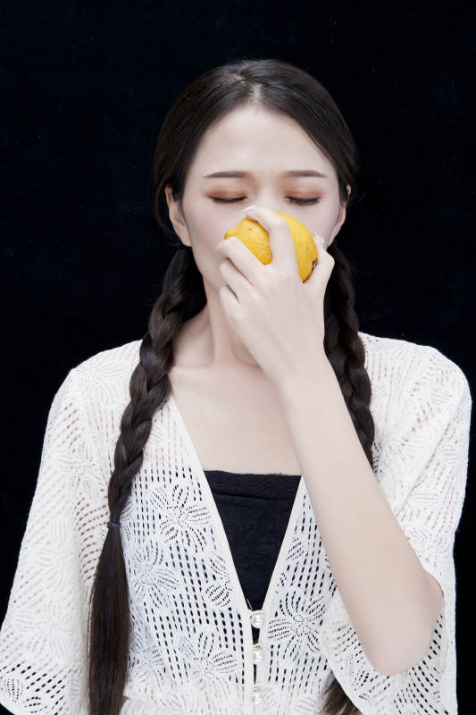 手拿柠檬身穿镂空连衣裙的亚洲可爱少女人像图片