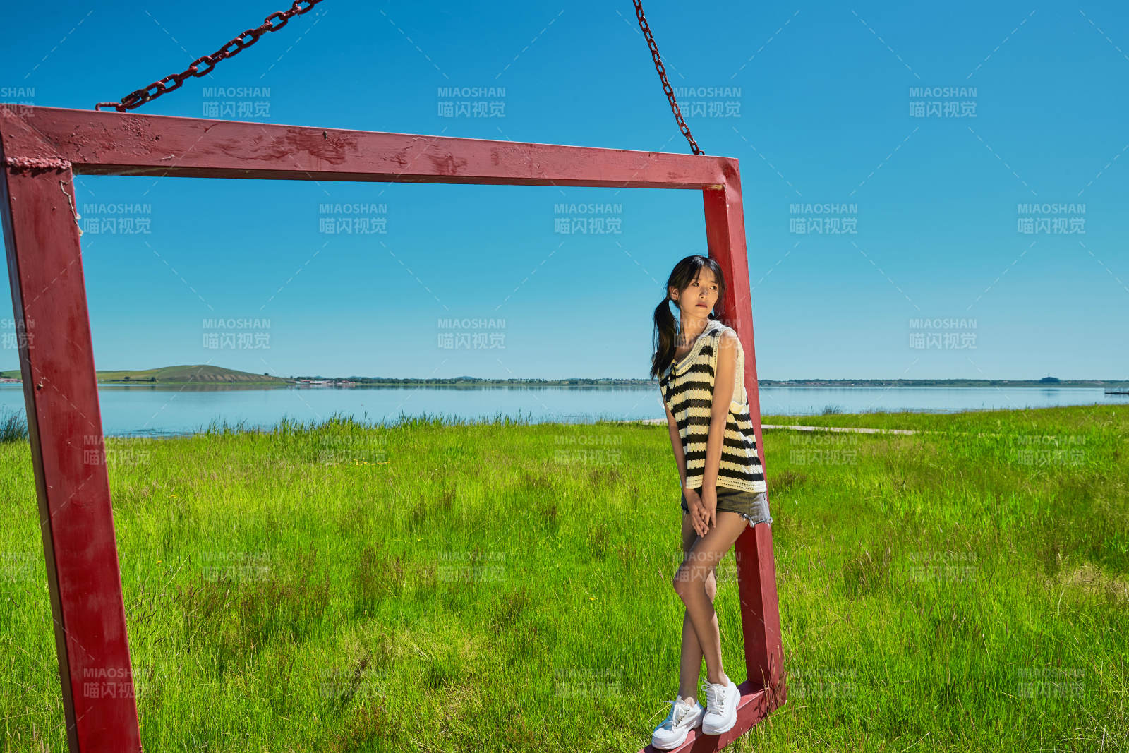 草原湖畔打卡点游玩拍照的亚洲少女图片