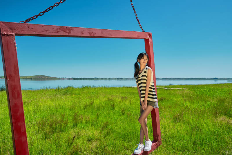 草原湖畔打卡点游玩拍照的亚洲少女图片