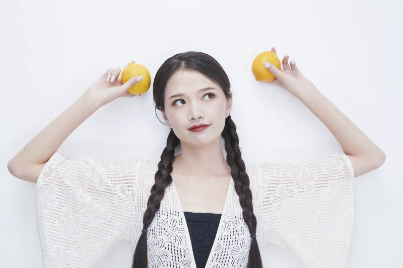 手拿柠檬身穿镂空连衣裙的亚洲可爱少女人像图片