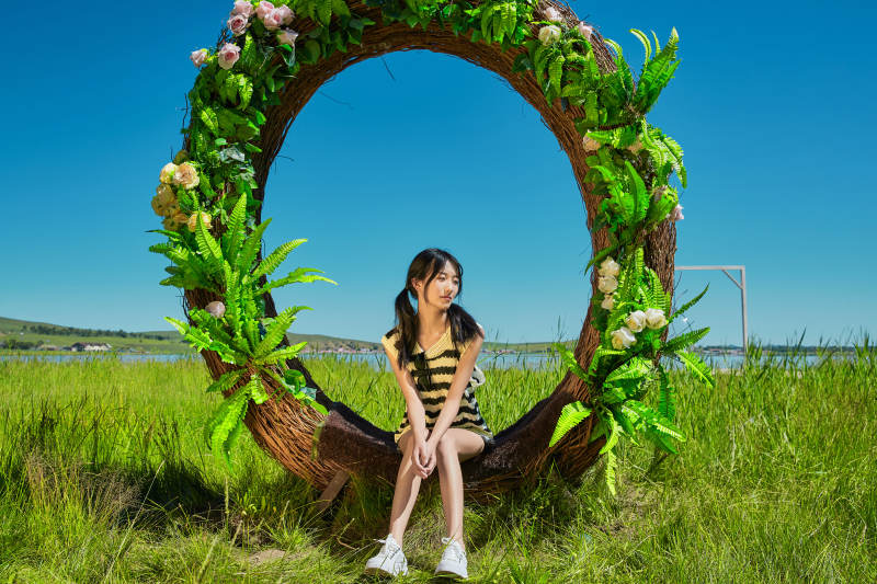 草原湖畔打卡点游玩拍照的亚洲少女图片