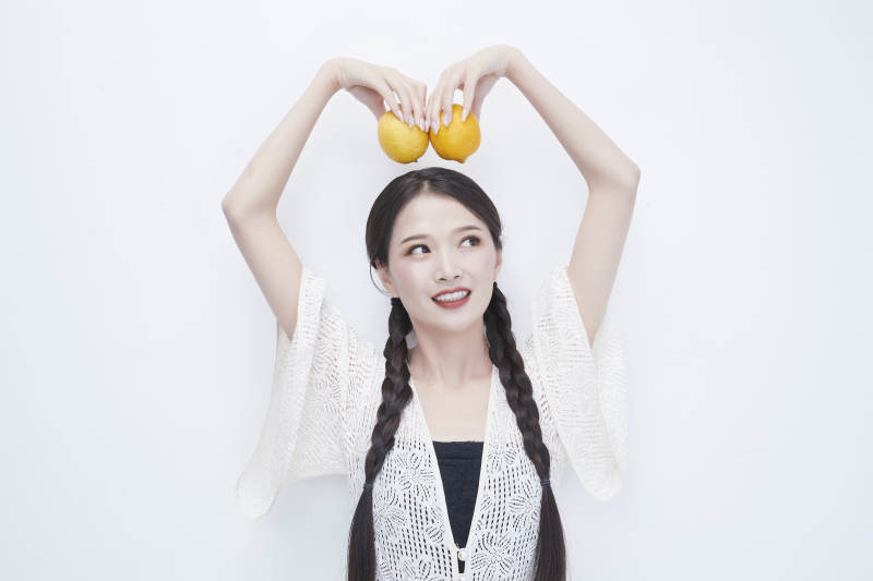 手拿柠檬身穿镂空连衣裙的亚洲可爱少女人像图片