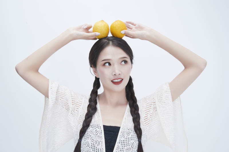 手拿柠檬身穿镂空连衣裙的亚洲可爱少女人像图片