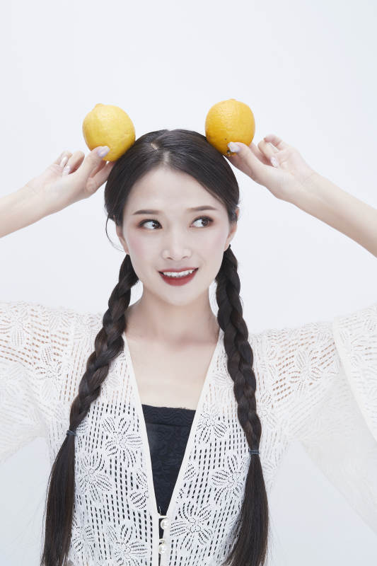 手拿柠檬身穿镂空连衣裙的亚洲可爱少女人像图片