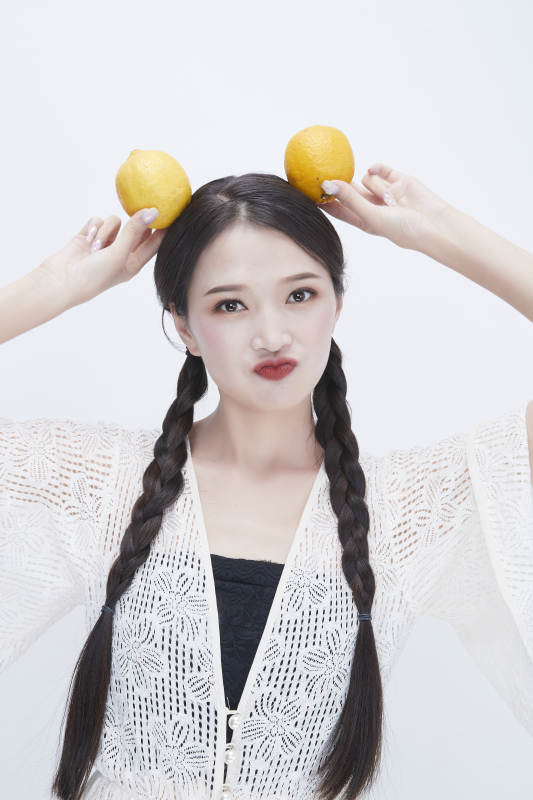 手拿柠檬身穿镂空连衣裙的亚洲可爱少女人像图片