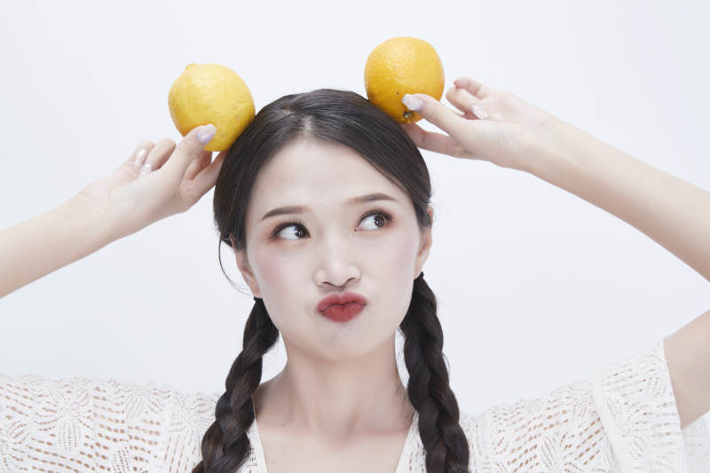 手拿柠檬身穿镂空连衣裙的亚洲可爱少女人像图片