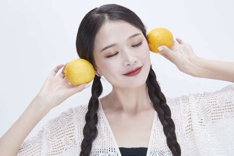 手拿柠檬身穿镂空连衣裙的亚洲可爱少女人像图片