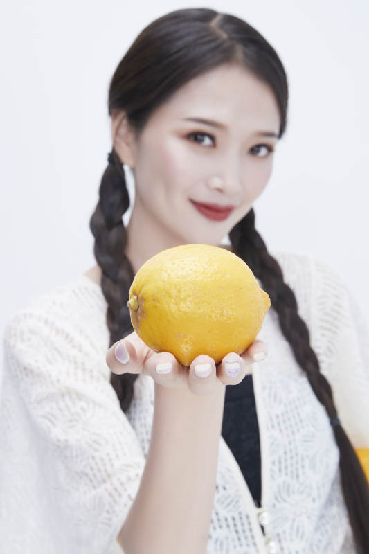 手拿柠檬身穿镂空连衣裙的亚洲可爱少女人像图片