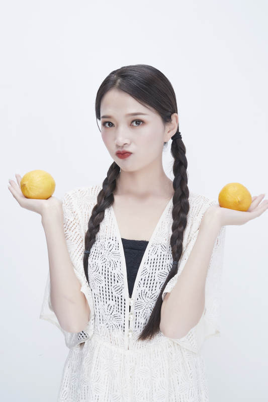 手拿柠檬身穿镂空连衣裙的亚洲可爱少女人像图片