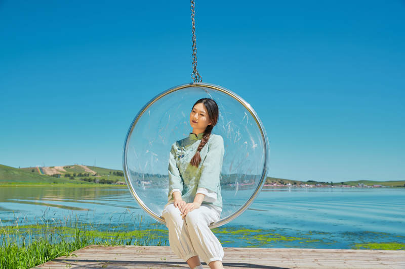 草原湖畔打卡点游玩拍照的亚洲少女图片