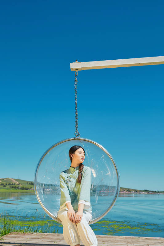 草原湖畔打卡点游玩拍照的亚洲少女图片