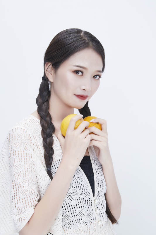 手拿柠檬身穿镂空连衣裙的亚洲可爱少女人像图片