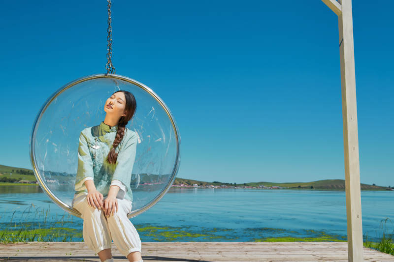 草原湖畔打卡点游玩拍照的亚洲少女图片