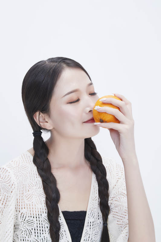 手拿橙子身穿镂空连衣裙的亚洲可爱少女人像图片