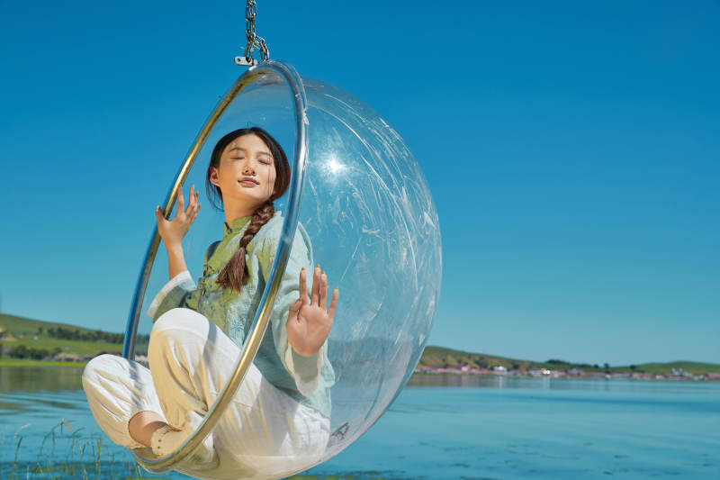 草原湖畔打卡点游玩拍照的亚洲少女图片