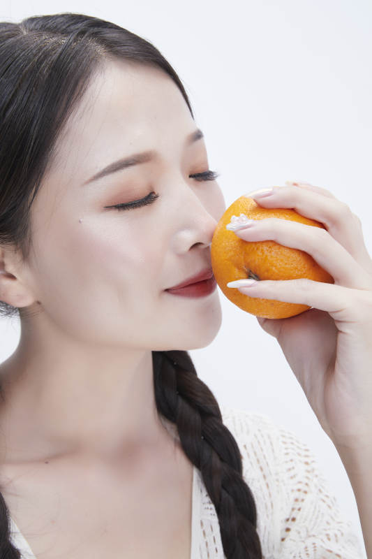 手拿橙子身穿镂空连衣裙的亚洲可爱少女人像图片