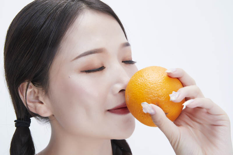 手拿橙子身穿镂空连衣裙的亚洲可爱少女人像图片