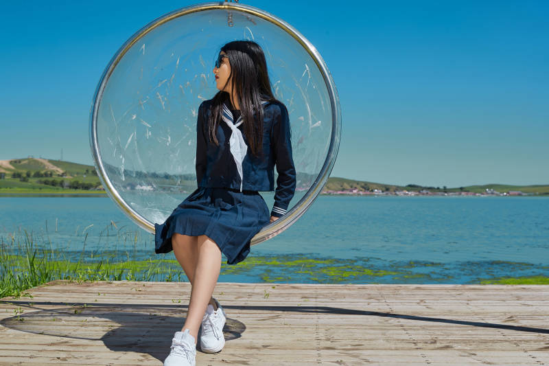 草原湖畔打卡点游玩拍照的亚洲少女图片