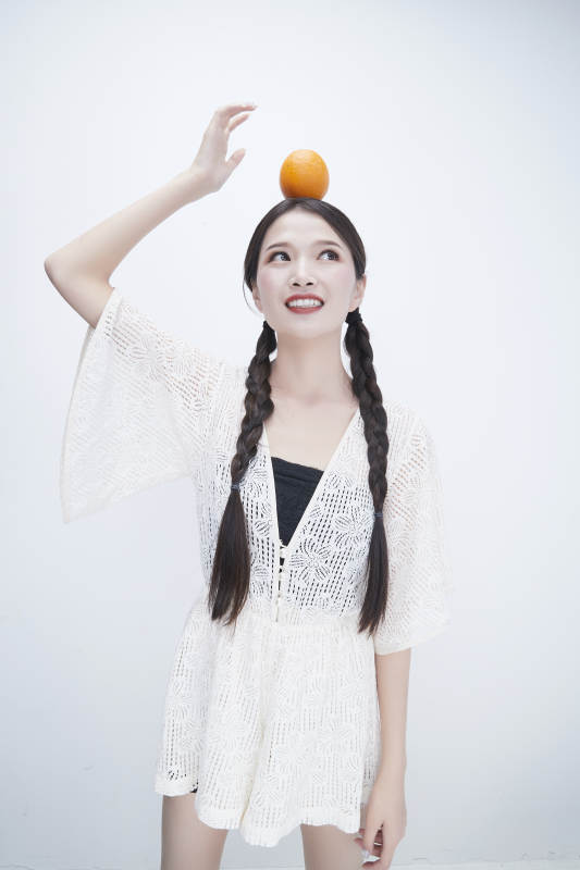 头顶橙子身穿镂空连衣裙的亚洲可爱少女人像图片
