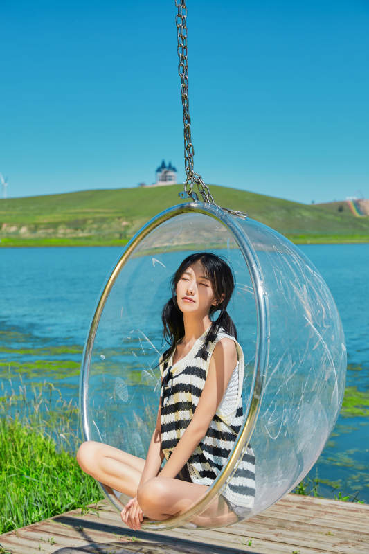 草原湖畔打卡点游玩拍照的亚洲少女图片