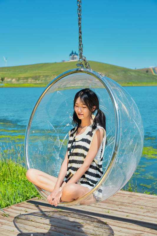 草原湖畔打卡点游玩拍照的亚洲少女图片