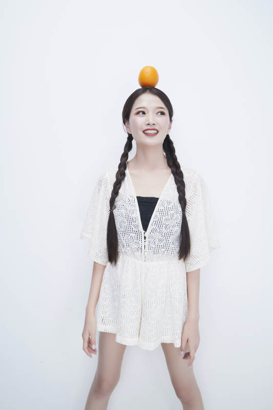 头顶橙子身穿镂空连衣裙的亚洲可爱少女人像图片